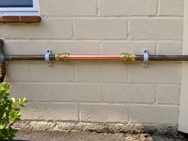 Repaired copper water pipe on an exterior brick wall with pipe clips in Manly Vale