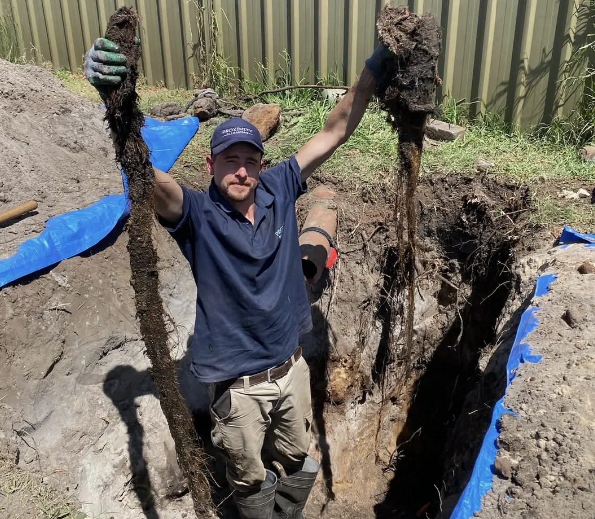 Tree roots cleared from a drain line in a trench